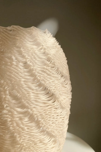 Gros plan de la texture aléatoire du vase sculptural Casus imprimé en PLA à base de coquilles de moules recyclées.
