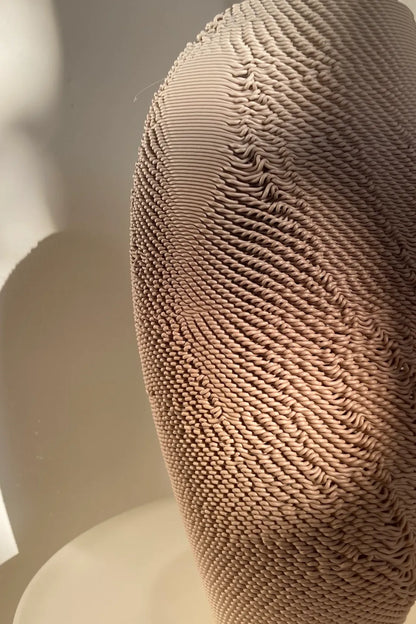 Gros plan de la texture aléatoire du vase sculptural Casus imprimé en PLA dégradé.