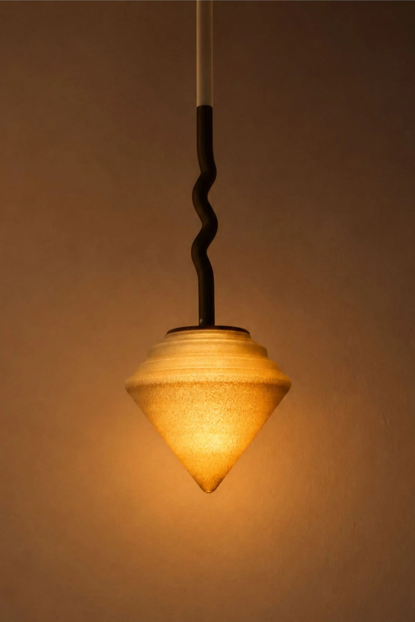 Suspension Pendulum taille M diffusant une lumière douce à travers une matière biosourcée imprimée en 3D.