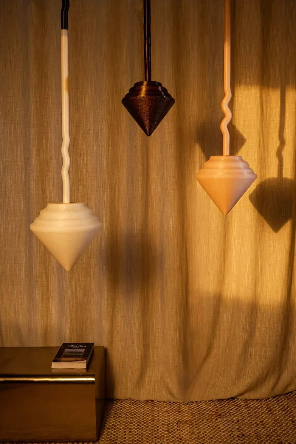 Triptyque de suspensions sculpturales Pendulum aux lignes élancées inspirées des pendules.