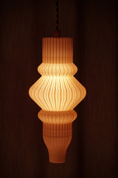 Suspension Vira diffusant une lumière douce à travers une matière biosourcée imprimée en 3D.